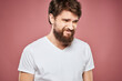 © SHOTPRIME STUDIO - Emotional bearded man in white T-shirt discontent pink background