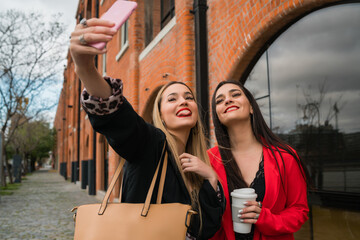 Two young friends taking a selfie with mobile phone.