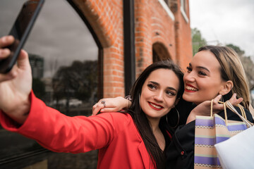 Wall Mural - Two young friends taking a selfie with mobile phone.