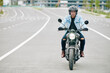 © DragonImages - Confident Vietnamese motorcyclist wearing helmet when riding fast on highway