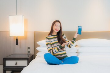 Portrait beautiful young asian woman using smart mobile phone on bed