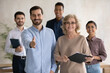 Portrait of smiling diverse businesspeople pose at workplace stretch hand for handshake get acquainted greeting. Happy multiracial employees meet welcome newcomer newbie to team. Employment concept.