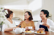 © DragonImages - Group of happy senior women drinking tea, eating cakes and discussing news at home