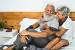 © Alessandro Biascioli - Happy senior couple smiling together in bed - Hipster mature people having funny bed time - Elderly lifestyle and love relationship concept