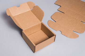 Wall Mural - Brown cardboard box on grey background, opened, empty inside