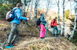 © Mirko Vitali - Friends group trekking in forest on french alps before sunset - Hikers with sticks walking togeether on mountain woods - Wanderlust travel concept with young people at excursion - Bright vivid filter