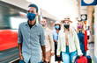 © Mirko Vitali - Multiracial crowd of people walking at railway station platform - New normal travel concept with young travelers covered by protective face mask - Focus on african american guy at left