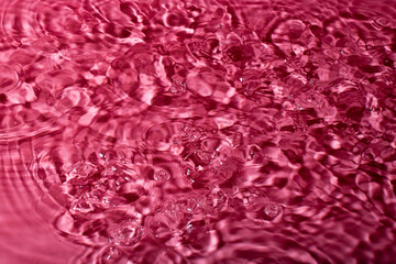 Wall Mural - splash of water on a red background. Abstract wallpaper