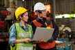 © godji10 - Selective focus. Supervisor and worker working in manufacturing factory on business day. Female industrial engineers have consult with colleagues while using laptop. Workplace gender equality concept