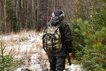 Hunter With A Gun And A Backpack In The Winter Forest