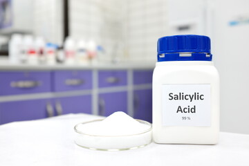 Sticker - Selective focus of pure salicylic acid chemical compound beside a petri dish with white crystalline powder white chemistry laboratory background. Chemical peel for skincare research.