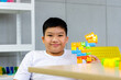 © pprothien - Asian boy play colorful brick toys during free time.