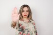 © Jihan - Young beautiful caucasian woman doing stop gesture with palm of the hand. Warning expression with negative and serious gesture on the face isolated over gray background.