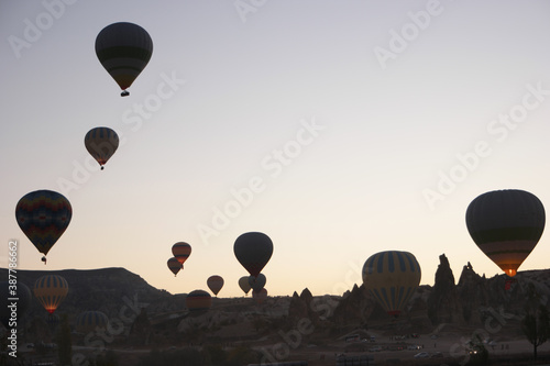 Colorful hot air balloons flying over mountains. Goreme, Cappadocia, Turkey. Tourism concept.