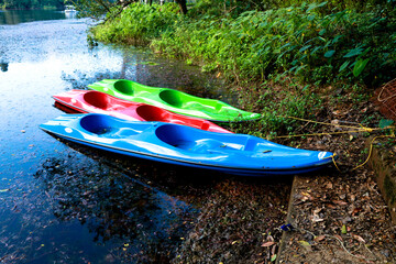 Fiber boats in different colors tied at a lake shore