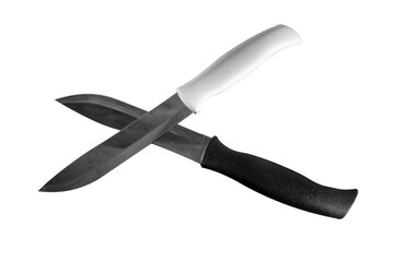 Two kitchen knives with white and black handles on a dark background.