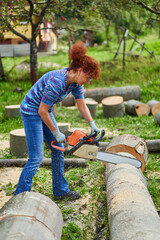 Wall Mural - Woman farmer using the chainsaw