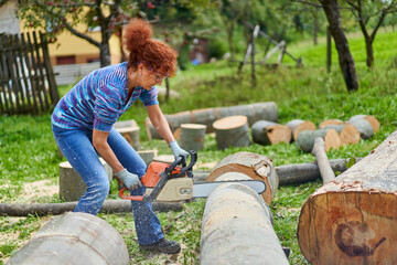 Wall Mural - Woman farmer using the chainsaw