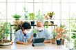 © artitwpd - Asian retirement grandfather and grandson wearing a face mask and live to sell plants on a tablet with fun. Retirement hobby and lifestyle. Family bonding between old and young. Concept of quarantine.