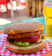 Poster - Fast food in bar served outdoor in sunny day, vegetarian hamburber and glass of cold beer