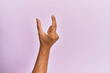 © Krakenimages.com - Arm and hand of caucasian young man over pink isolated background picking and taking invisible thing, holding object with fingers showing space