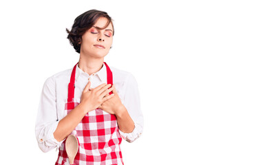 Poster - Beautiful young woman with short hair wearing professional cook apron smiling with hands on chest with closed eyes and grateful gesture on face. health concept.