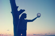 © allasimacheva - The girl holds the moon in her hands. sunset on the sea. Dreams come true.
