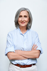 Confident smiling mature business woman standing arms crossed isolated on white background. Older senior businesswoman, 60s grey-haired lady executive leader coach looking at camera, vertical portrait