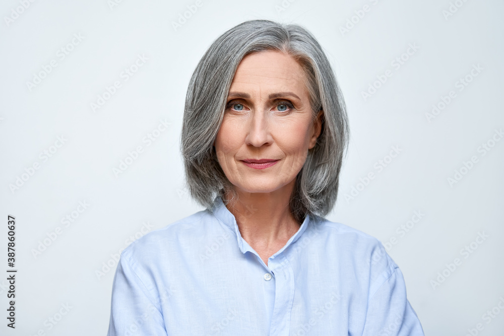Confident beautiful mature business woman standing isolated on white background. Older senior businesswoman, 60s grey haired lady professional looking at camera, close up face headshot portrait. - obrazy, fototapety, plakaty 
