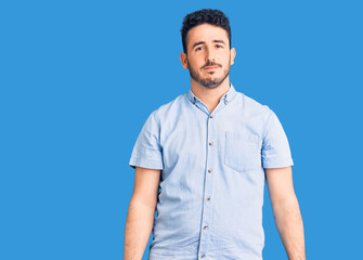 Young hispanic man wearing casual clothes with serious expression on face. simple and natural looking at the camera.