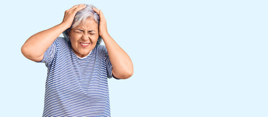 Wall Mural - Senior woman with gray hair wearing casual striped clothes suffering from headache desperate and stressed because pain and migraine. hands on head.