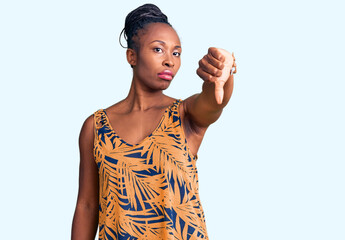 Wall Mural - Young african american woman wearing casual clothes looking unhappy and angry showing rejection and negative with thumbs down gesture. bad expression.