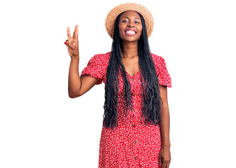 Wall Mural - Young african american woman wearing summer hat showing and pointing up with fingers number three while smiling confident and happy.