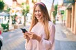 © Krakenimages.com - Young caucasian girl smiling happy using smartphone at the city.