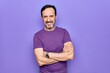 © Krakenimages.com - Middle age handsome man wearing casual purple t-shirt standing over isolated background happy face smiling with crossed arms looking at the camera. Positive person.