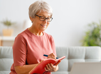 Wall Mural - senior woman is using laptop