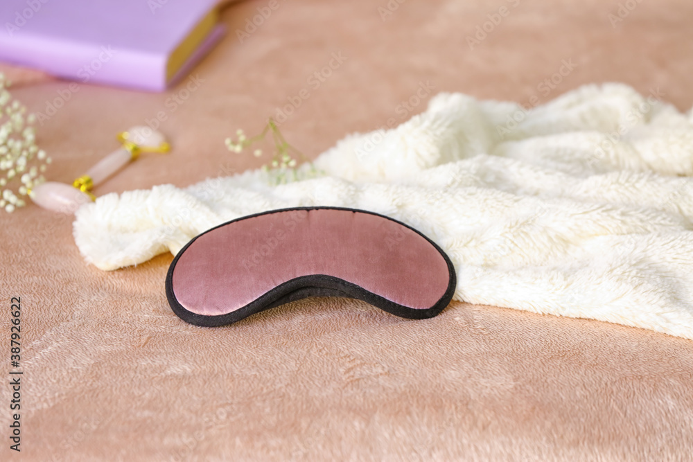 Sleeping mask and plaid on bed