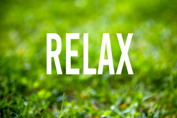 The word relax on green grass garden background.