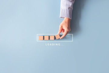 Loading, hand putting wood cube in progress bar.