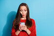 © deagreez - Photo of astonished girl use smartphone social media information wear pullover isolated blue color background