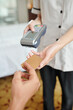 © DragonImages - Hotel maid with payment terminal taking credit card and accepting payment for room service