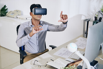 Wall Mural - serious young indian programmer in headset testing interface for new virtual reality application