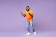 © ViDi Studio - Full length of screaming young african american man 20s wearing basic casual orange t-shirt clenching fists doing winner gesture looking camera isolated on pastel violet background studio portrait.