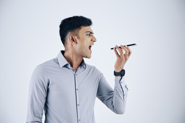 Wall Mural - emotional young indian entrepreneur shouting in microphone of smartphone