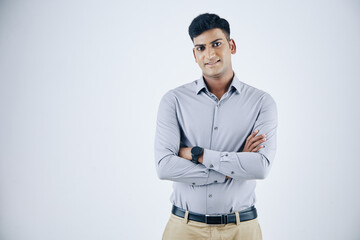 Wall Mural - portrait of confident young indian entrepreneur crossing arms and smiling at camera