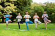 © Syda Productions - fitness, sport and healthy lifestyle concept - group of happy people doing yoga at summer park