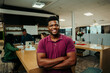 © Prins Productions - African American male designer standing smiling with cross arms relaxing during lunch break in office lounge