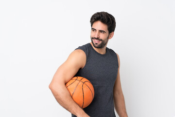 Young handsome man with beard over isolated white background playing basketball