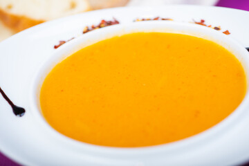 Lentil soup in a white plate on the table in a restaurant