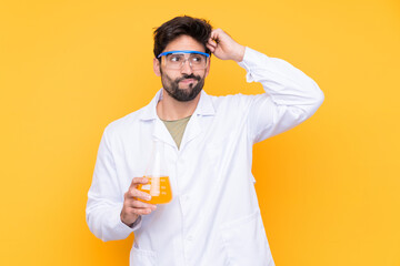 Young scientific man over isolated yellow background having doubts and with confuse face expression